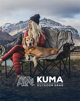 Femme et son chien installés dans un fauteuil de camping Kuma Outdoor Gear en montagne